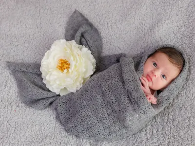 newborn-neonato-avvolto-grigio-fiore-bianco-sicilia.webp