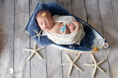 newborn-neonato-fascia-celeste-posa-minimale-sud-sicilia.webp